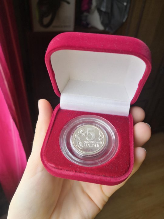 монета в защитном пластиковом капсуле на бархатной подушке