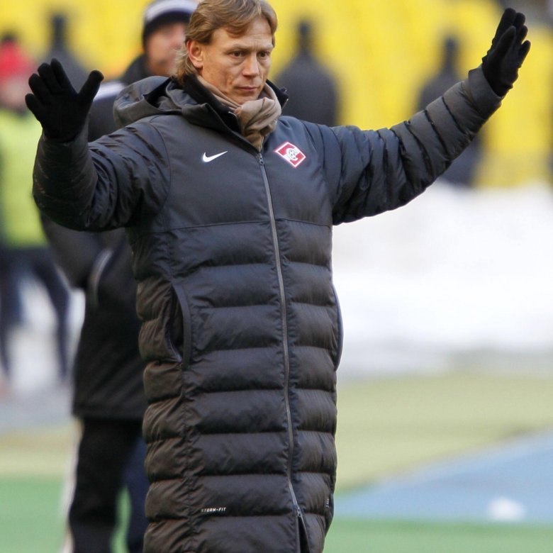 тренер в пальто на стадионе