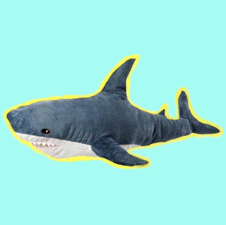 Фото игрушечной акулы на зеленом фоне